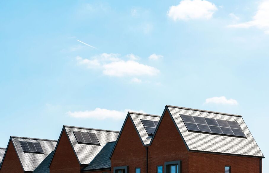 A row of houses with solar panels on their rooves