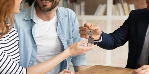 happy couple receiving keys from new own propert