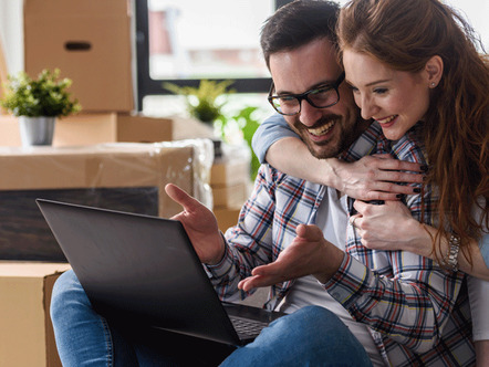 Couple checking progress of conveyancing on laptop 