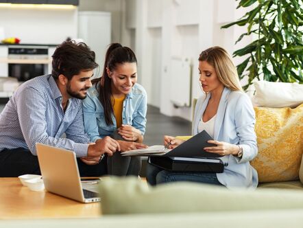 A young couple meeting with an estate agent