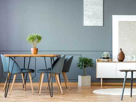 Grey apartment interior with chairs at dining table 