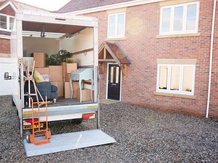 A moving van filled with boxes in front of a house