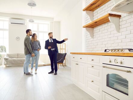 An estate agent showing a couple round a kitchen