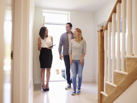 An estate agent showing a couple around a home